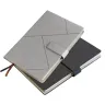 Toma fotográfica de libretas promocionales con tapa rígida en colores gris y negro, diseño de líneas geométricas abstractas, broche magnético y separador de listón para grabado empresarial.