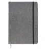 Toma fotográfica de libretas promocionales con textura de corcho sintético en color gris, elástico de cierre negro y listón separador para grabado corporativo.